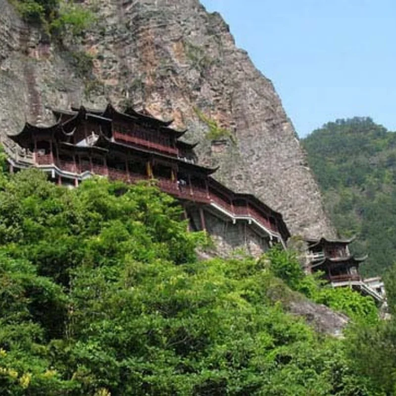 昆明西山懸崖上的古建築群沿著山壁而建，傳統中式亭台樓閣與長廊依山勢延伸，周圍被翠綠山林環繞。建築依附陡峭岩壁而立，展現壯觀的山岳景觀與歷史文化特色，是昆明西山著名的觀景與旅遊景點之一。