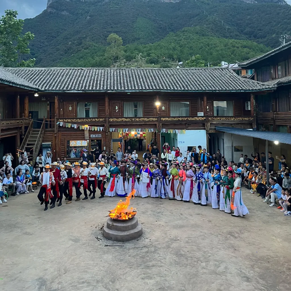 瀘沽湖摩梭族篝火晚會，圍繞火堆跳舞，穿著傳統民族服飾的文化表演場景。