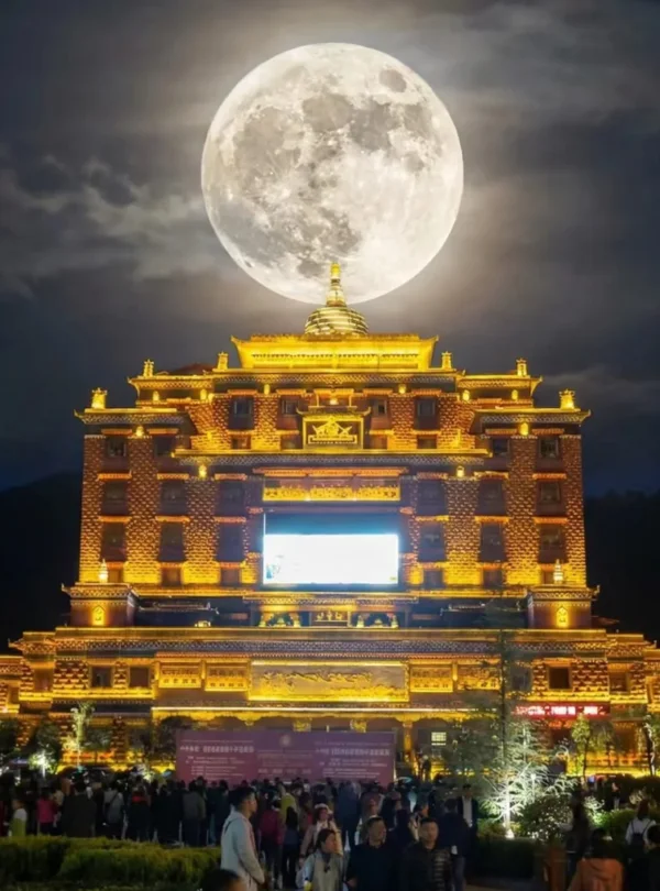 夜幕下的 香巴拉時輪壇城 金碧輝煌，巨大的滿月高懸於建築上方，形成震撼視覺效果。