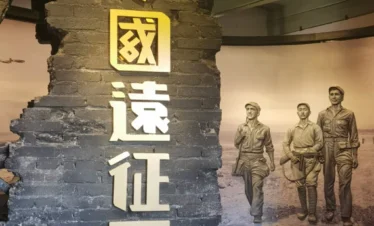 雲南陸軍講武堂舊址展館內部展示區，牆面以破裂磚牆造型呈現「中國遠征軍」字樣，旁側展示歷史人物雕塑與戰時場景背景，重現雲南陸軍講武堂舊址與中國遠征軍相關的歷史記憶與軍事文化