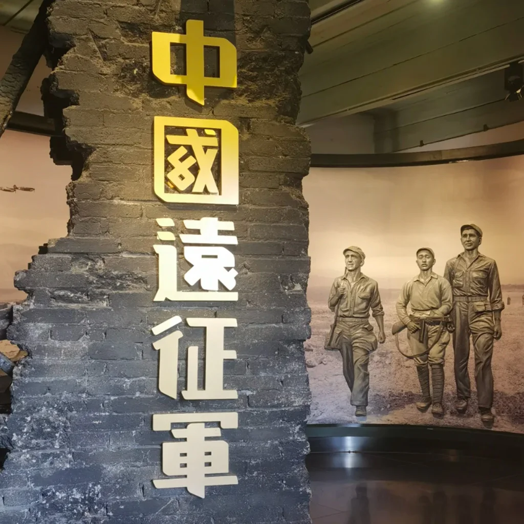 雲南陸軍講武堂舊址展館內部展示區，牆面以破裂磚牆造型呈現「中國遠征軍」字樣，旁側展示歷史人物雕塑與戰時場景背景，重現雲南陸軍講武堂舊址與中國遠征軍相關的歷史記憶與軍事文化