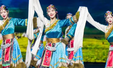 在 麗江宋城千古情 舞台上，演員身著民族服飾翩翩起舞，色彩鮮豔，動作優美，展現濃鬱的民族文化與藝術魅力。