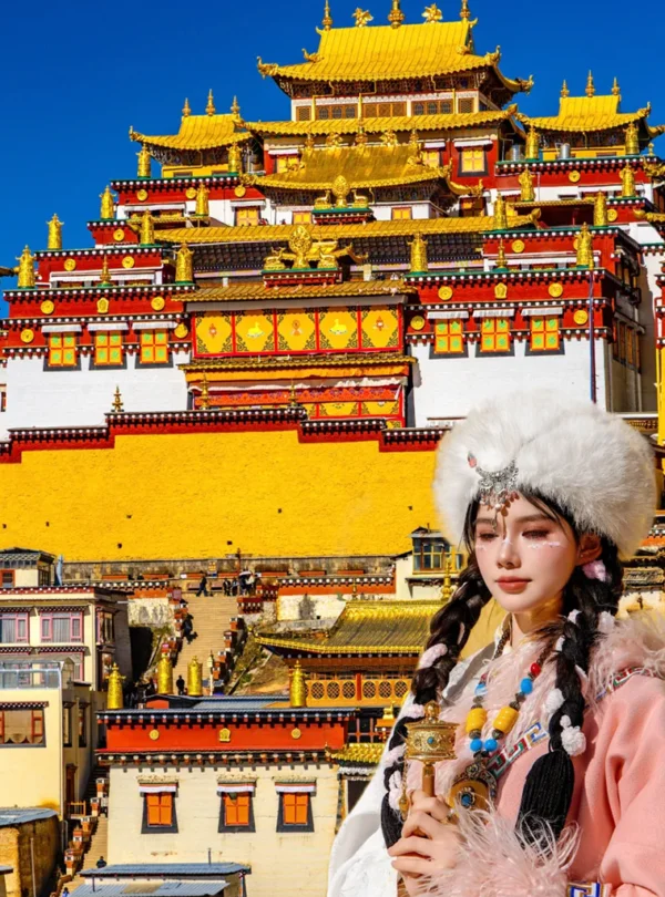 在 松贊林寺 前，遊客身著藏族傳統服飾拍照留念，金頂寺廟群莊嚴宏偉，色彩鮮豔，人物與藏式建築相互映襯，充滿民族風情。
