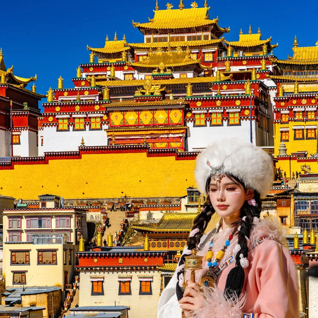在 松贊林寺 前，遊客身著藏族傳統服飾拍照留念，金頂寺廟群莊嚴宏偉，色彩鮮豔，人物與藏式建築相互映襯，充滿民族風情。