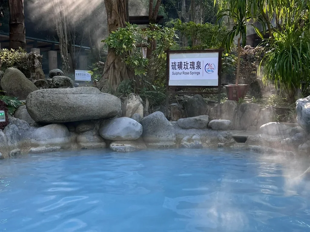 騰衝熱海的森林溫泉，乳藍色的泉池被熱帶綠意環繞，陽光穿過樹林灑在瀰漫的白霧上，是騰衝最療癒的泡湯秘境。