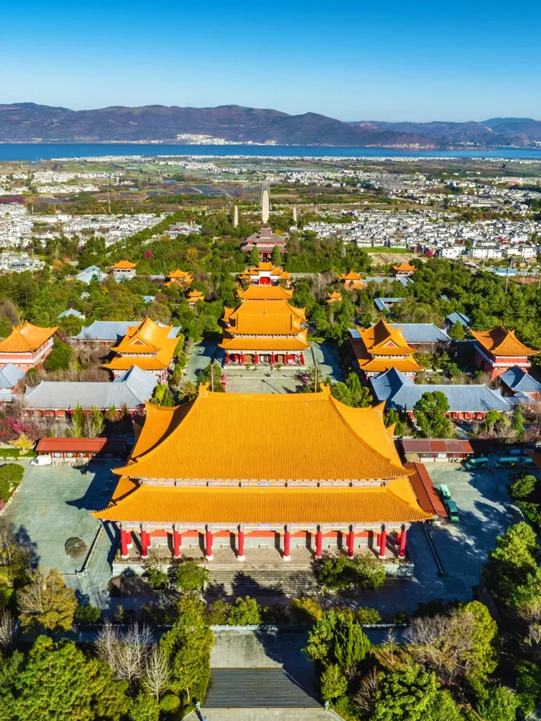 大理崇聖寺三塔航拍視角，寺院建築群與遠方洱海景觀一覽無遺。