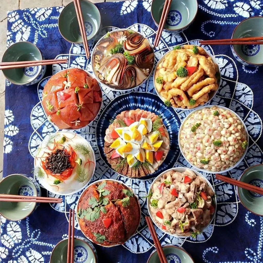 道地大理「土八碗」，傳統雲南宴席料理。8 道特色佳餚擺放在藍色扎染桌布上，是白族經典宴席。