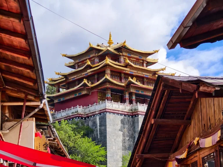 香格里拉獨克宗古城大佛寺，金頂層疊藏式古殿雄偉莊嚴，聳立高原山巔，夾在原木藏式民居古巷之間，滿載千年藏傳佛教聖地風韻。