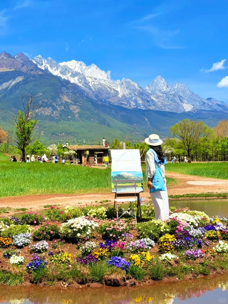 麗江春季景色，玉龍雪山下綠色田野與花海，遊客寫生拍照的自然風光。