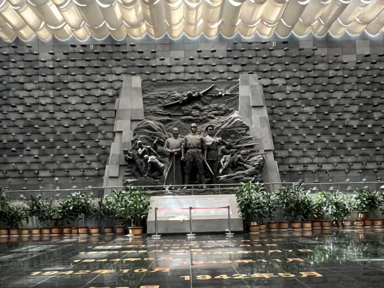 騰衝國殤墓園抗戰紀念館大廳，以中央雕塑與滿牆鋼盔為核心，再現滇西抗戰的崢嶸歲月，是對遠征軍將士的莊嚴致敬。