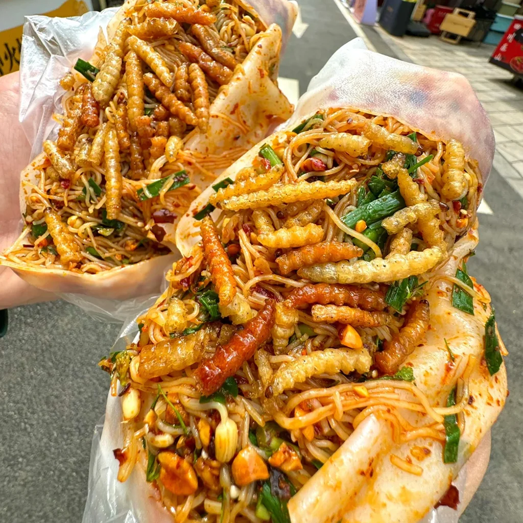 Tengchong rice noodle rolls 地道騰衝裹卷粉,雲南街頭美食特色。香辣米線搭配酥脆昆蟲幼蟲、韭菜、花生,包裹在薄米皮中。