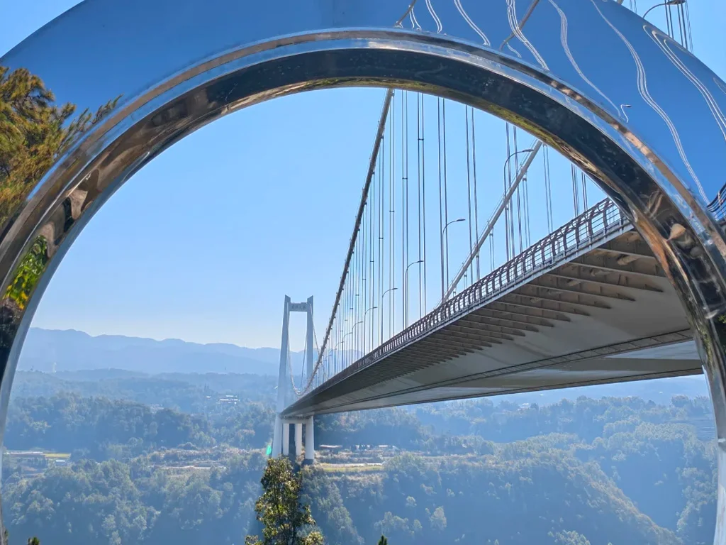 騰衝龍江大橋，橫跨龍江河谷的亞洲高橋，透過景觀平台的鏡面拱門取景，拍出科幻感十足的橋體全景。