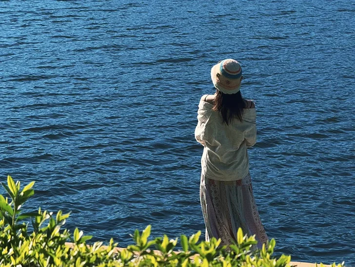 騰衝北海濕地公園的湖岸風光，深藍色的湖面波光粼粼，搭配前景綠葉，拍出超治愈的度假感背影照。