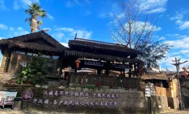 騰衝司莫拉佤族村的傳統茅草屋，青石板路、紅燈籠與藍天相映，是保存完好的佤族原生態古村落。