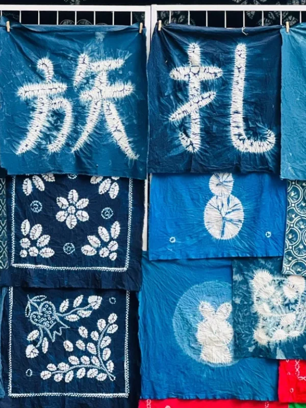Bai tie dye craft Dali rlb2wiylrg4nkqnya457kj3209qbvv7dyw6t18d7wg 大理白族扎染工藝,藍染布料呈現傳統圖案與漢字,展現民族特色。