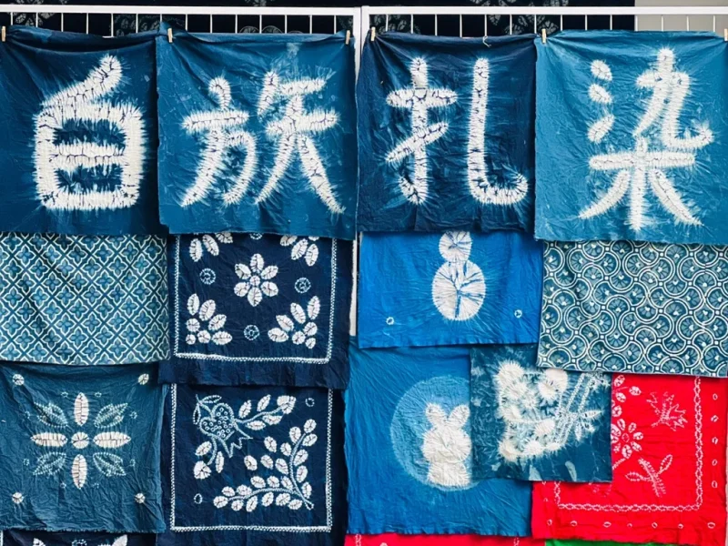 Bai tie dye craft Dali rlb2wiyo75n8ydm9rn5po9fqjkcs3tq3cjdt877rsg 大理白族扎染工藝,藍染布料呈現傳統圖案與漢字,展現民族特色。