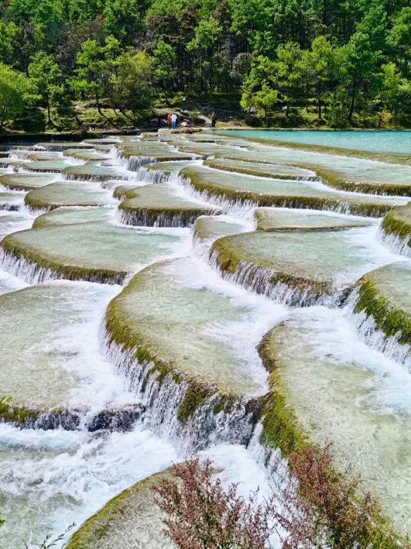 藍月谷水流沿石灰岩層層流動，形成獨特的階梯水台景觀。