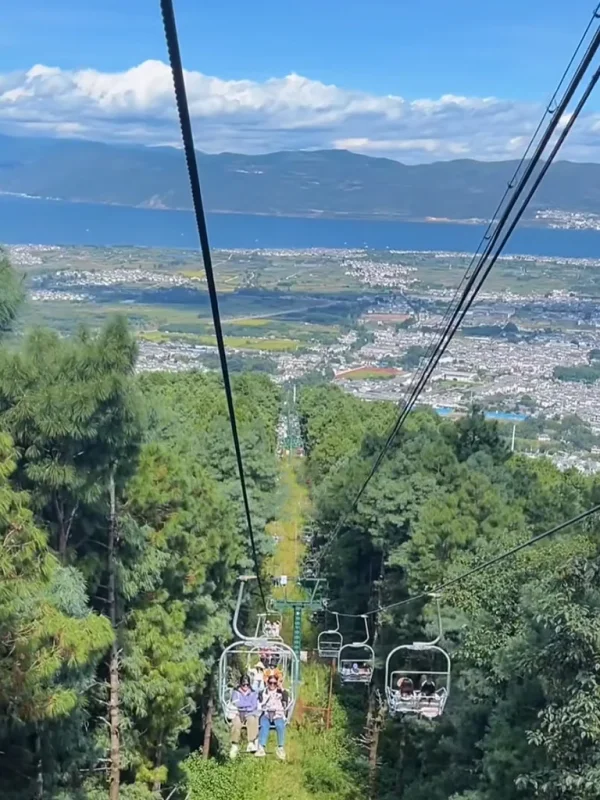 Dali Cangshan Cableway rlaw2oaa7fkqwfs1vue3ekisk5i6lv6ti1eu7sw7cw 大理蒼山索道景觀,遊客搭乘纜車穿越森林山坡,俯瞰洱海與城市風光。