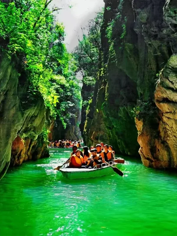 Jiuxiang Cuiyin Gorge 遊客乘船穿越昆明九鄉翠蔭峽,兩側為高聳石灰岩峽谷與翠綠水面。
