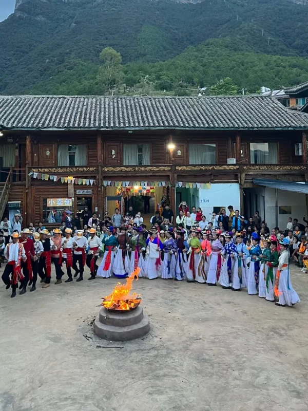 瀘沽湖摩梭族篝火晚會，圍繞火堆跳舞，穿著傳統民族服飾的文化表演場景。