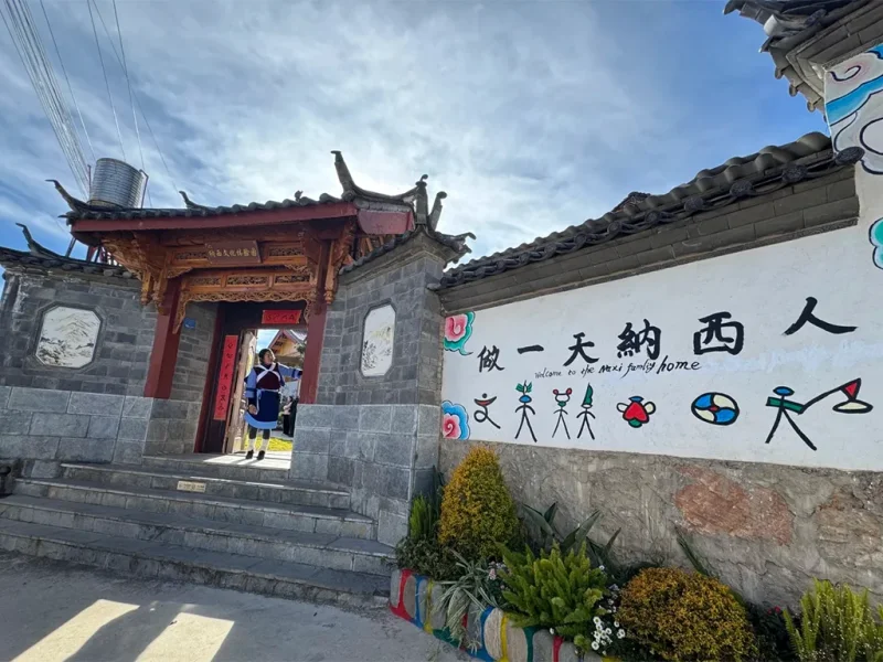 麗江納西族村落入口，傳統建築與文化圖騰裝飾。