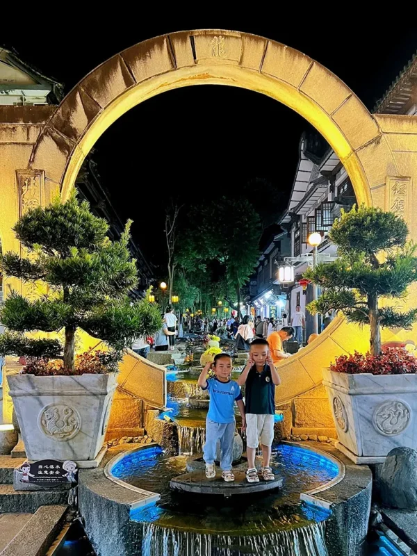 Night View of Dali Ancient City 2 大理古城夜景,月亮門與流水景觀點亮夜晚,人們享受熱鬧街景。