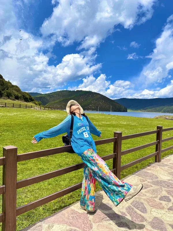 Shangri La Dacuo 1 在普達措屬都湖的草原邊,靠著木柵欄張開雙臂,藍天白雲、草原湖泊相映,是香格里拉最自由的高原瞬間。