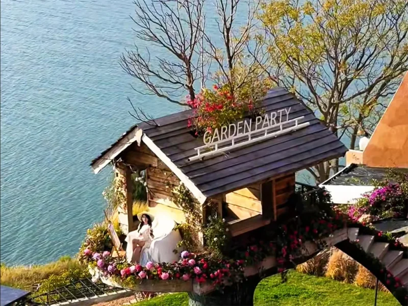 Slow Living in a Dali Erhai Log Cabin 大理洱海小木屋慢生活場景,湖畔木屋環繞花卉,一人悠閒享受寧靜時光。