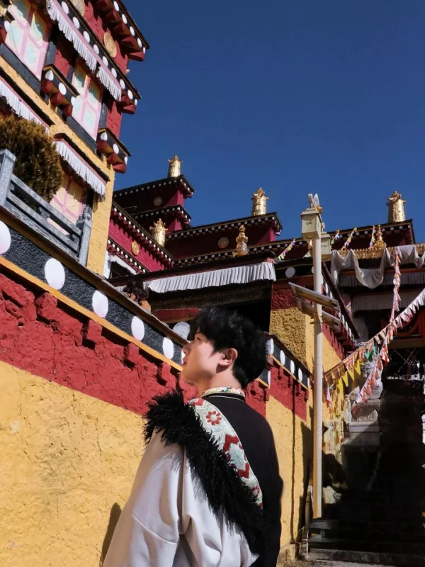 Songzanlin Monastery Shangri La 3 在松贊林寺的紅黃牆前,穿著藏服側身而立,寺廟的金頂與經幡相映,是香格里拉最具藏式氛圍的打卡畫面。