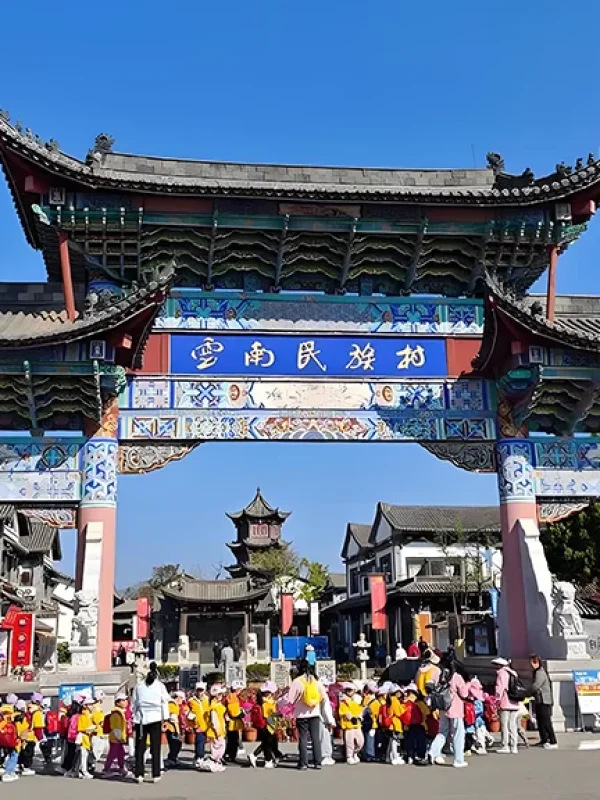 Yunnan Ethnic Village 雲南民族村入口牌樓,傳統建築與遊客活動交織,展現文化氛圍。